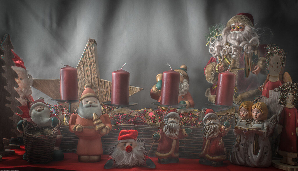 Red candle with pine cones and blurred bokeh lights, perfect for holiday decor inspiration.